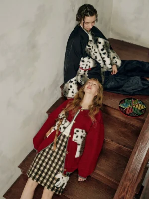Burgundy spotted pony cardigan outfit styled on wooden stairs with playful equestrian knitwear details