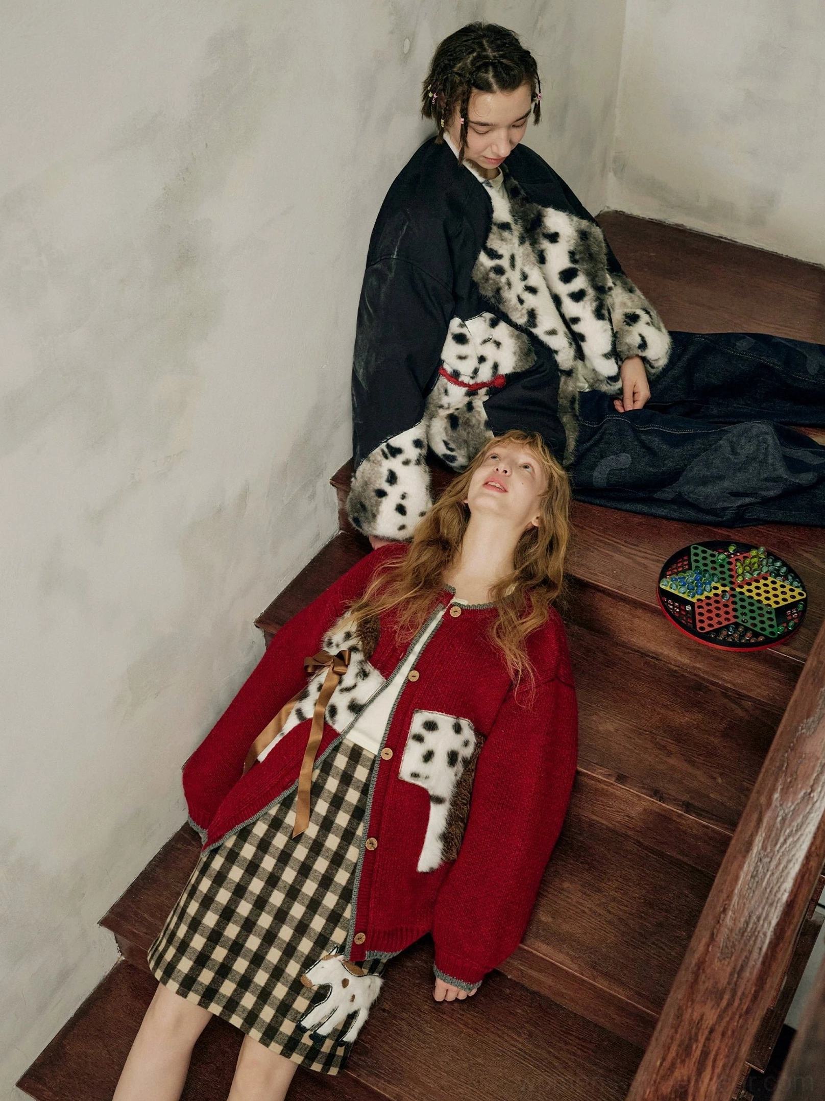 Burgundy spotted pony cardigan outfit styled on wooden stairs with playful equestrian knitwear details