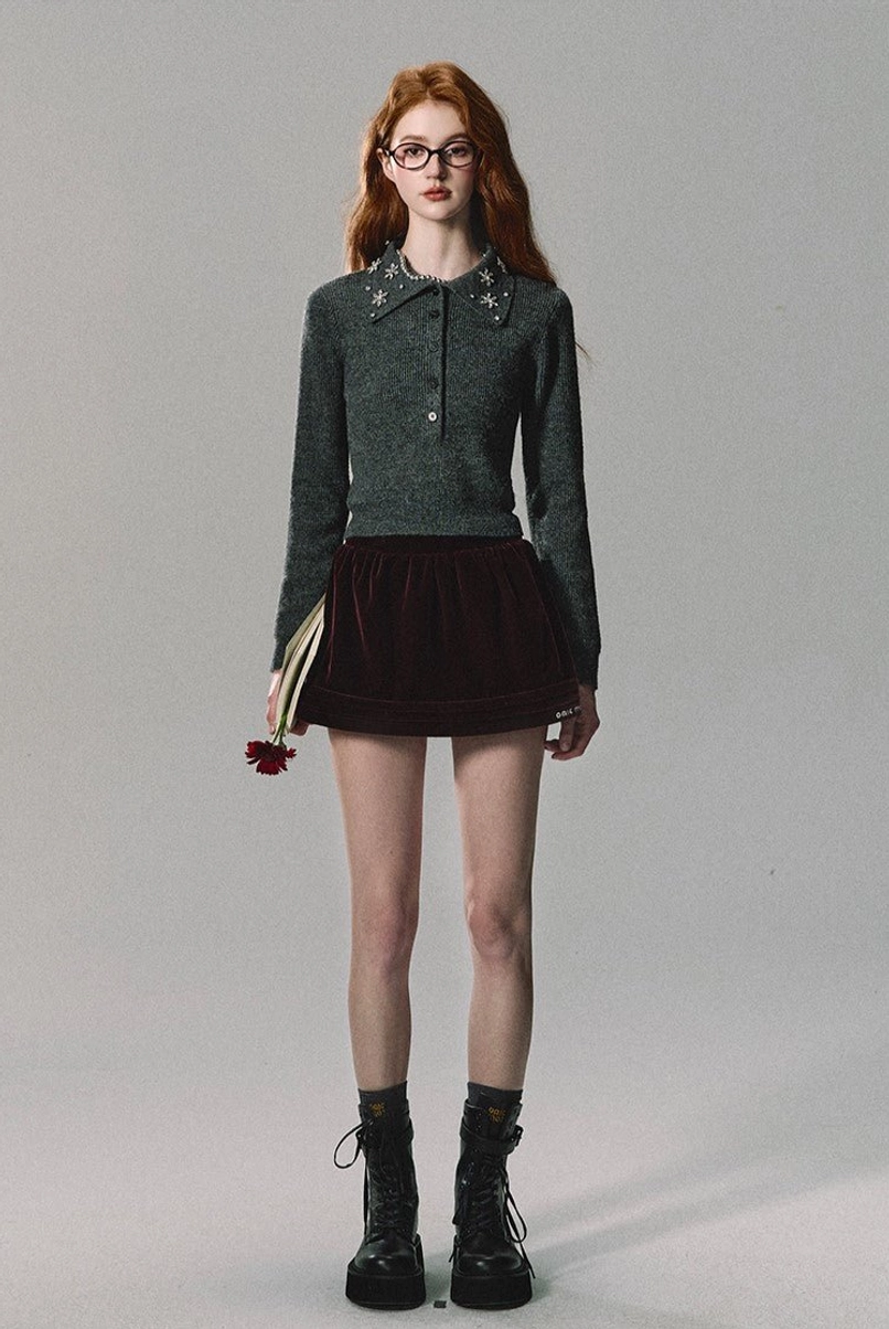 Burgundy velvet flared mini skirt styled with a grey cropped polo knit top and combat boots in a Seoul fashion outfit
