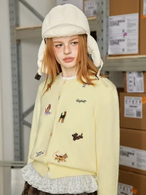 Butter yellow puppy embroidered knit cardigan with dog embroidery and lace trim styled with a puffer bucket hat