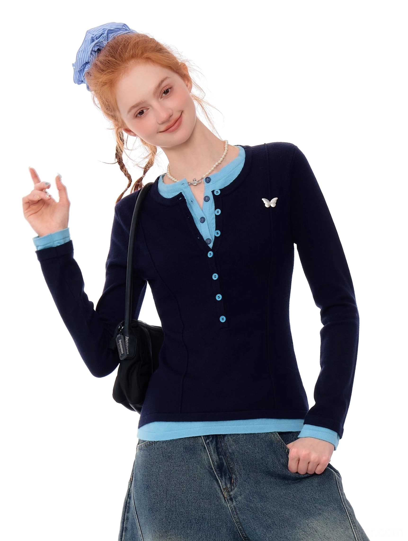 Women's slim navy butterfly knit Henley top with blue trim styled with a denim skirt and shoulder bag