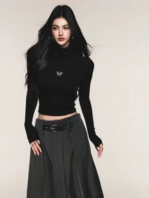 Black butterfly cropped turtleneck knit top styled with a high-waisted pleated skirt in a minimalist Seoul streetwear outfit