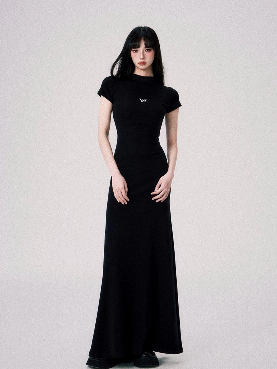 Butterfly emblem fitted maxi dress color and style presentation with mock neck short sleeves and fishtail hem