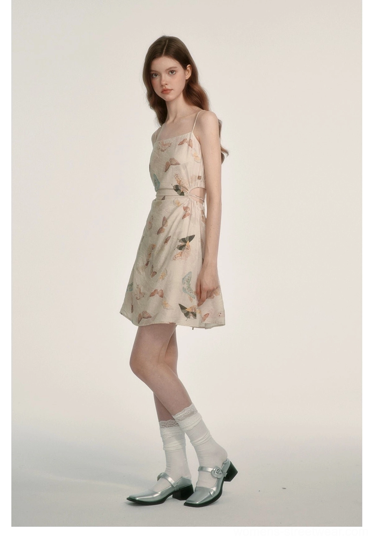 Side full-body view of a butterfly print square neck mini dress with spaghetti straps and defined waist