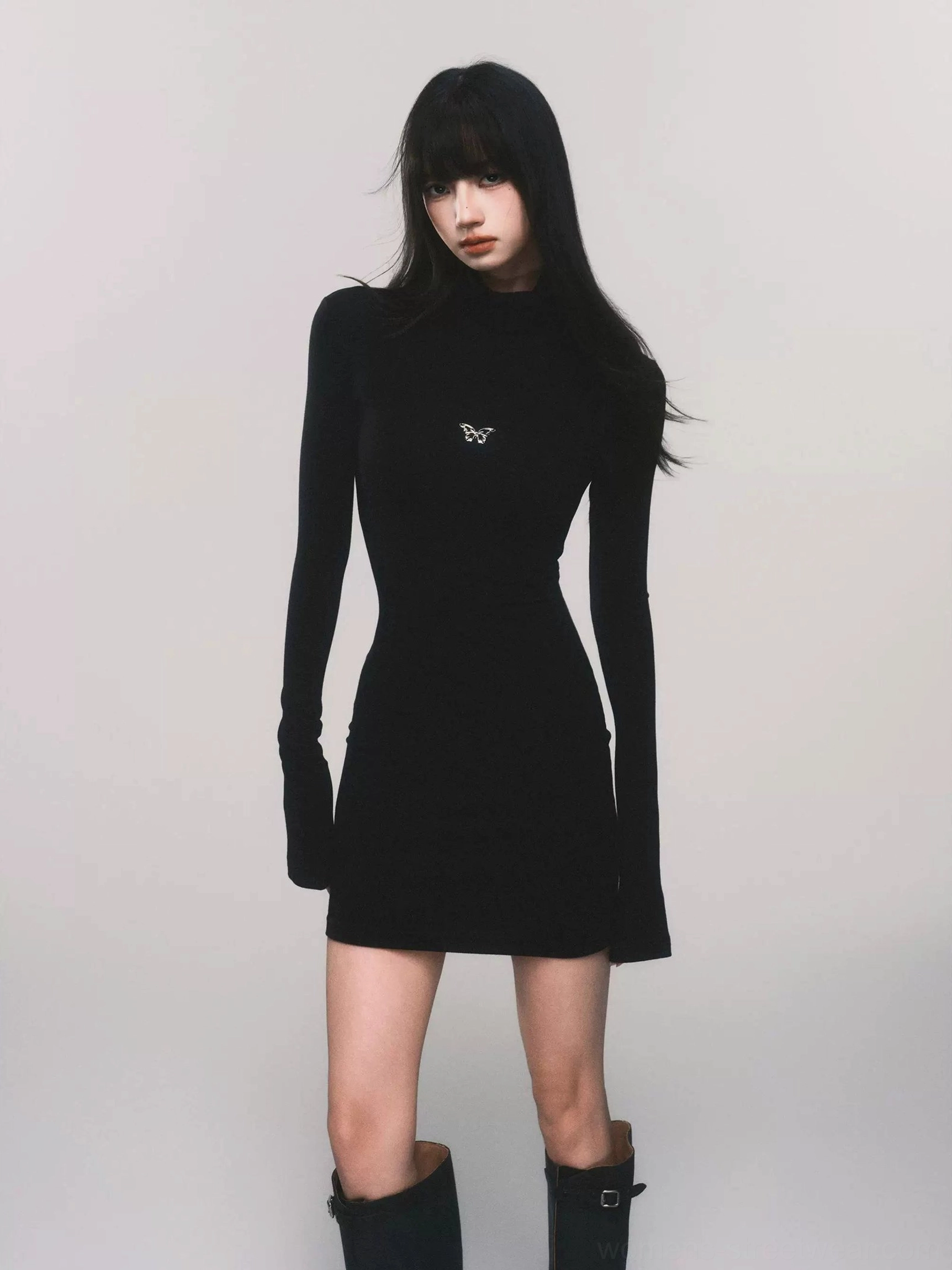 Black butterfly turtleneck bodycon knit mini dress styled with knee-high boots in studio