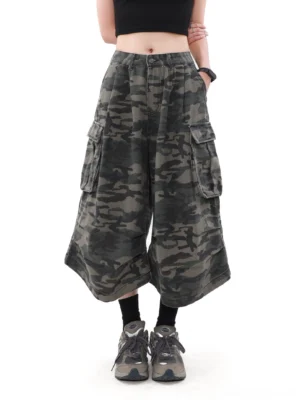 Front detail of camouflage cargo culottes showing the button waistband, relaxed oversized fit, wide cropped silhouette, and urban streetwear cotton fabric
