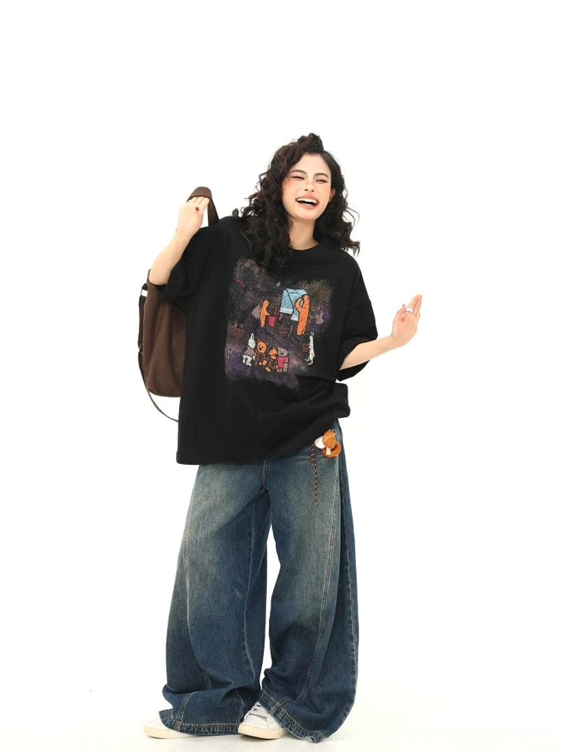 Three-quarter view of black oversized T-shirt with camping bear chest graphic paired with dark wash wide-leg denim