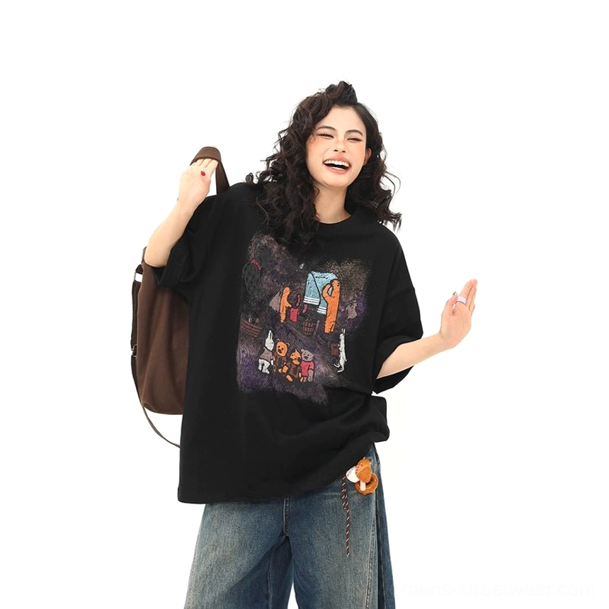Front three-quarter view of campfire bear graphic black oversized T-shirt with relaxed streetwear styling and dark jeans