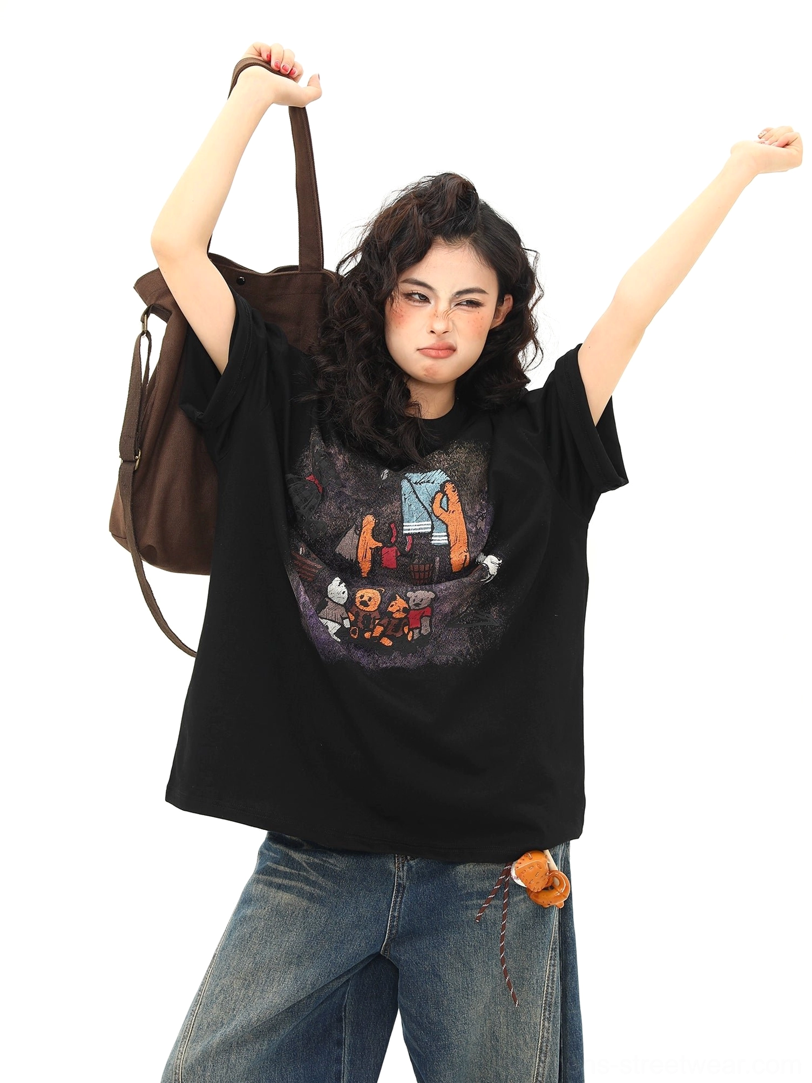 Front full-body view of black campfire bear graphic oversized T-shirt with wide-leg jeans and casual tote bag styling