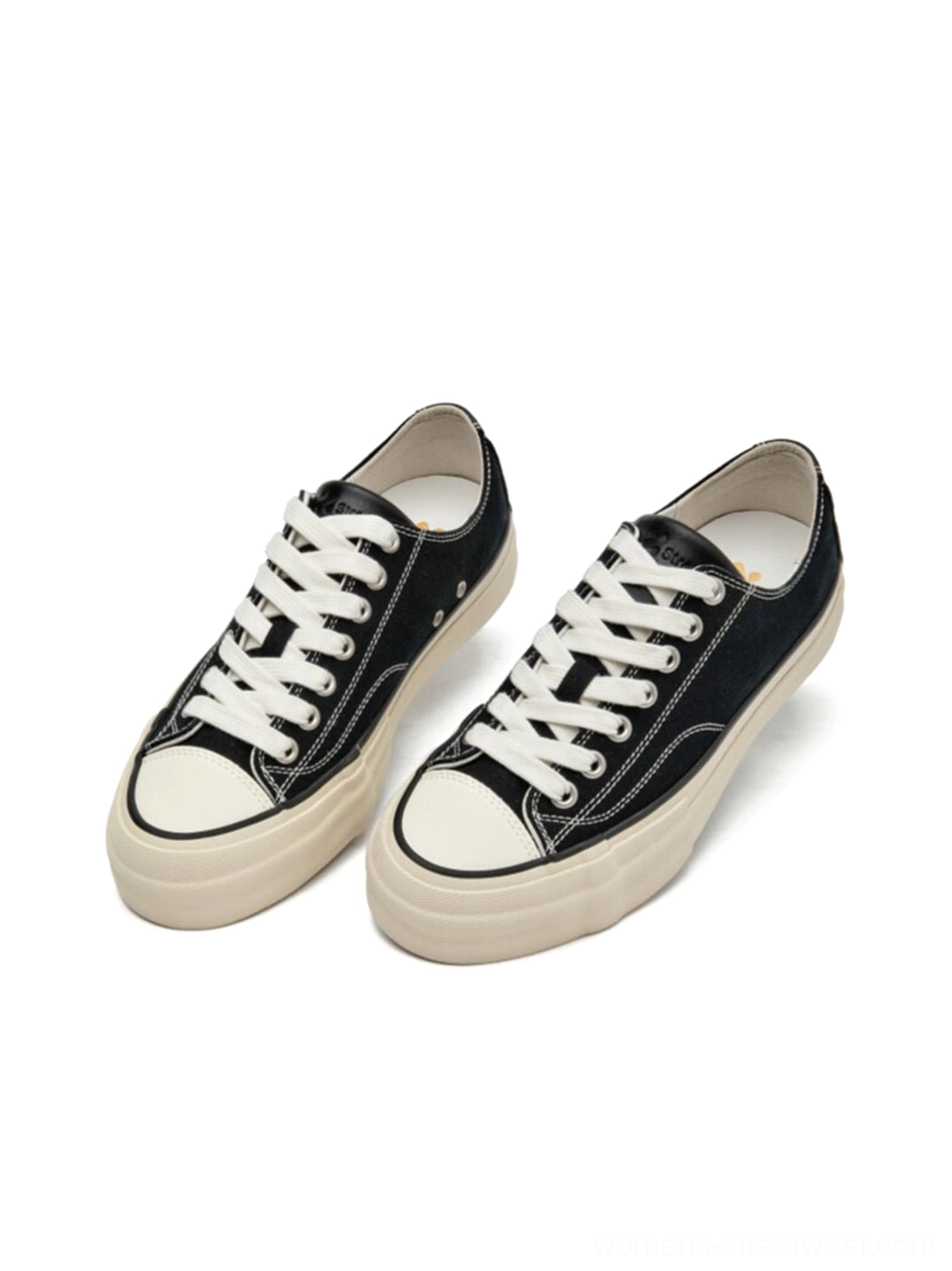 Front oblique flat display of black and white canvas platform sneaker pair with cork midsole, clean minimalist product photography