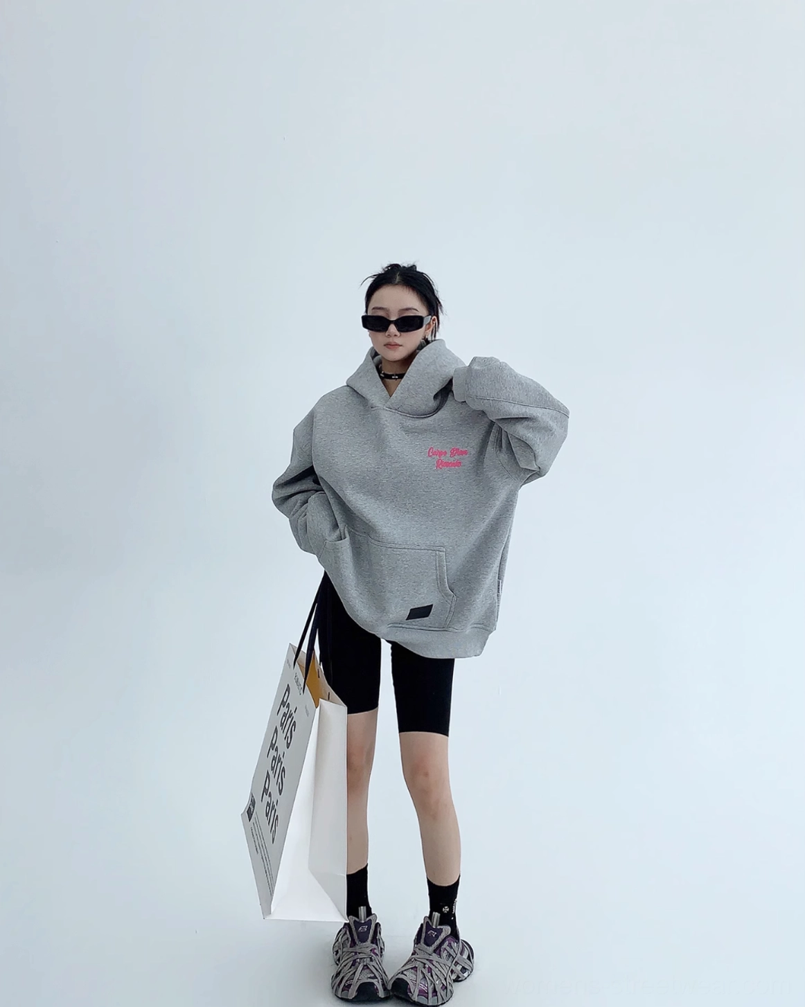 Full body front view of gray Carpe Diem pink script oversized hoodie with kangaroo pocket and biker shorts