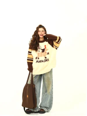 Cute cartoon dachshund knit sweater with cream body and brown yellow striped sleeves styled with wide-leg jeans and tote bag