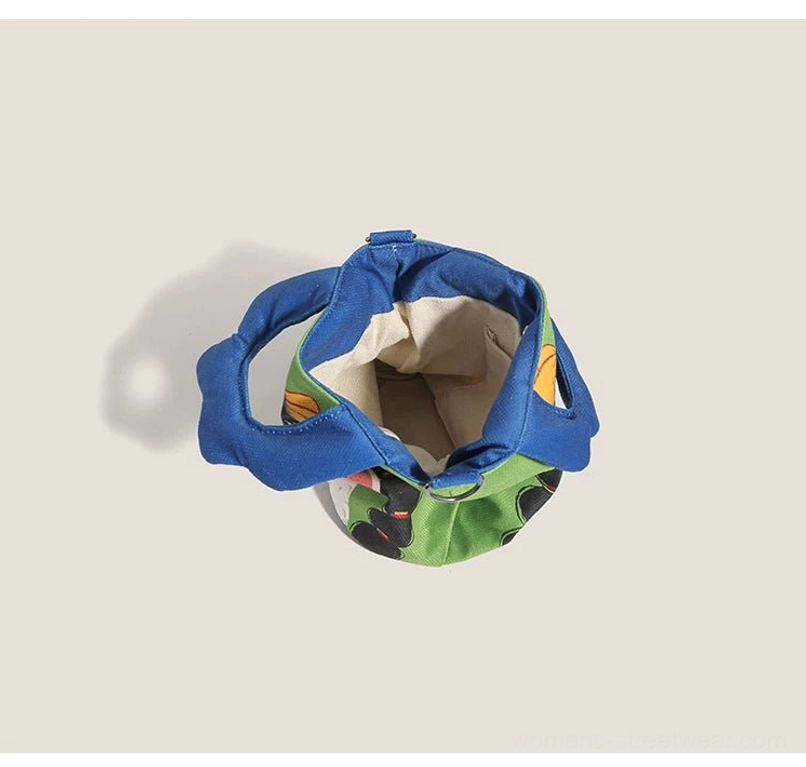 Interior top-down opening view of cartoon canvas tote revealing off-white polyester lining and blue outer handles construction