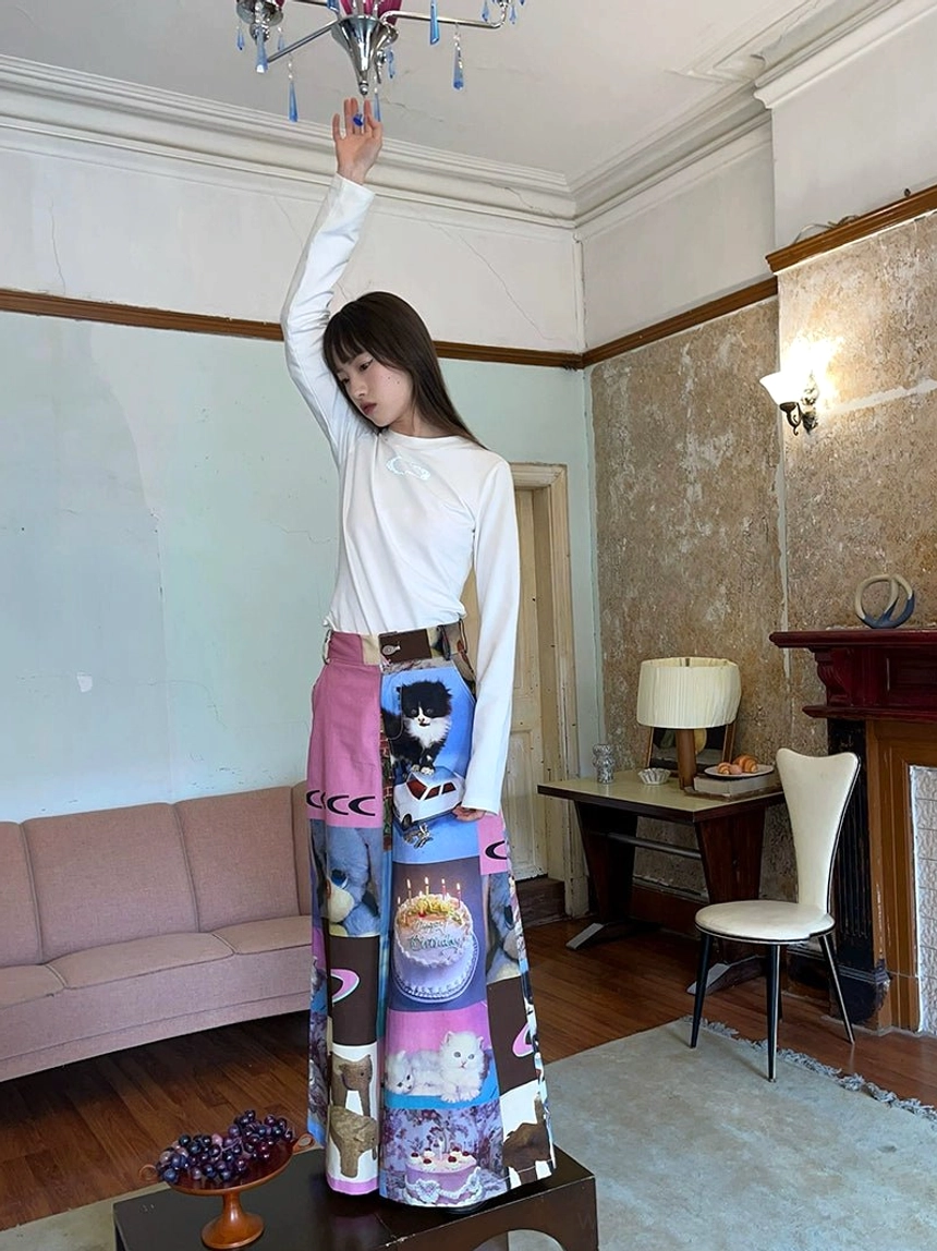 Front full-length view of cat birthday cake print patchwork wide-leg pants with a high-waist pink waistband