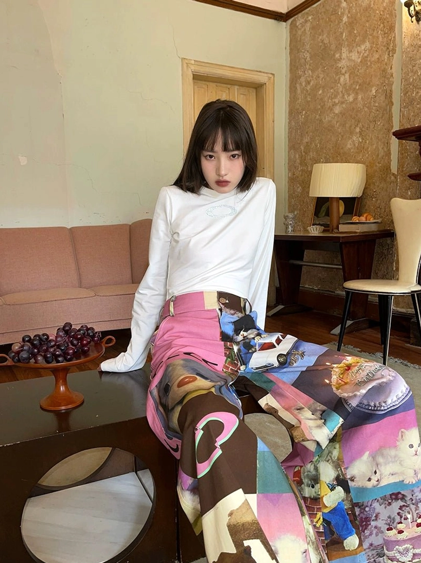 Front seated outfit view of pink waistband cat birthday cake print wide-leg streetwear pants