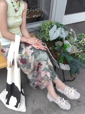 Celestial moon star low-heel sport Mary Janes styled with a floral skirt at an outdoor shop entrance