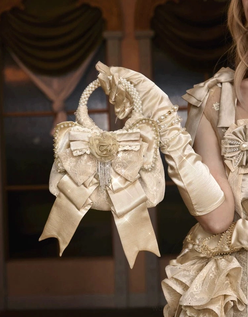 Close side view of champagne pearl handle rosette bow mini handbag with satin glove styling