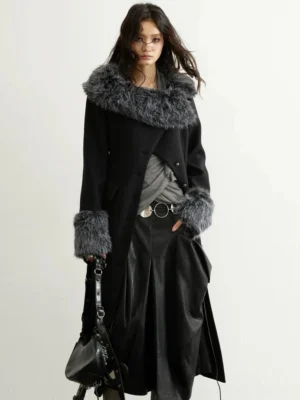 Front full-body view of a charcoal black long wool blend coat with icy gray faux-fur collar and matching fur cuffs in a minimalist studio