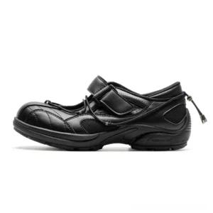 Charcoal black Trek-Strap tech Mary Jane sneakers shown in left profile with a wide hook-and-loop strap, breathable mesh panels, heel toggle cord, quilted toe cap, and thick sculpted sport outsole