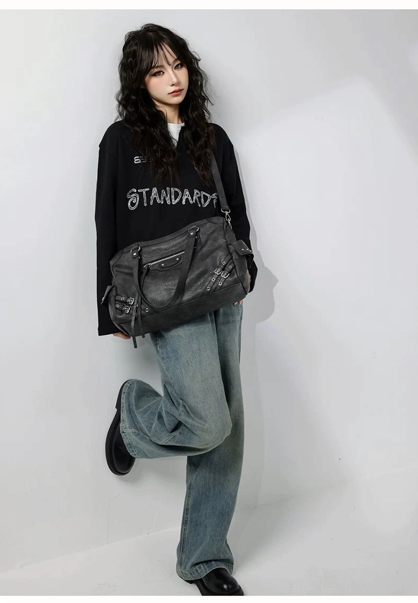 Charcoal buckle rider tote bag crossbody styling with front zipper pocket silver hardware and urban streetwear outfit