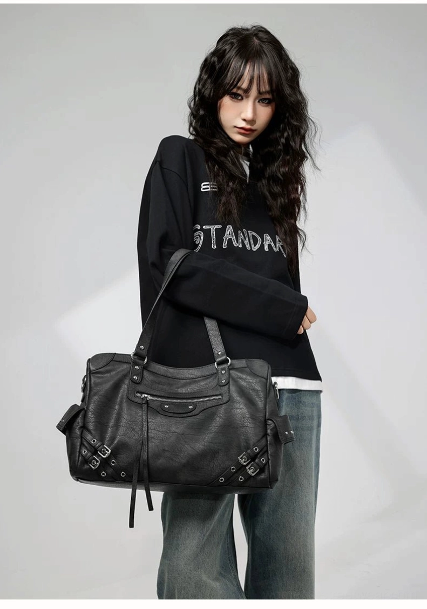 Charcoal buckle rider tote bag worn front view with distressed faux leather silver studs and punk streetwear styling