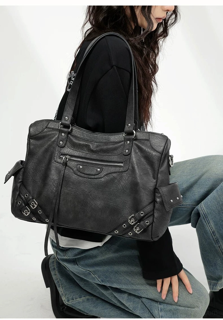 Charcoal buckle rider tote bag close shoulder view showing worn faux leather texture and full buckle hardware decoration