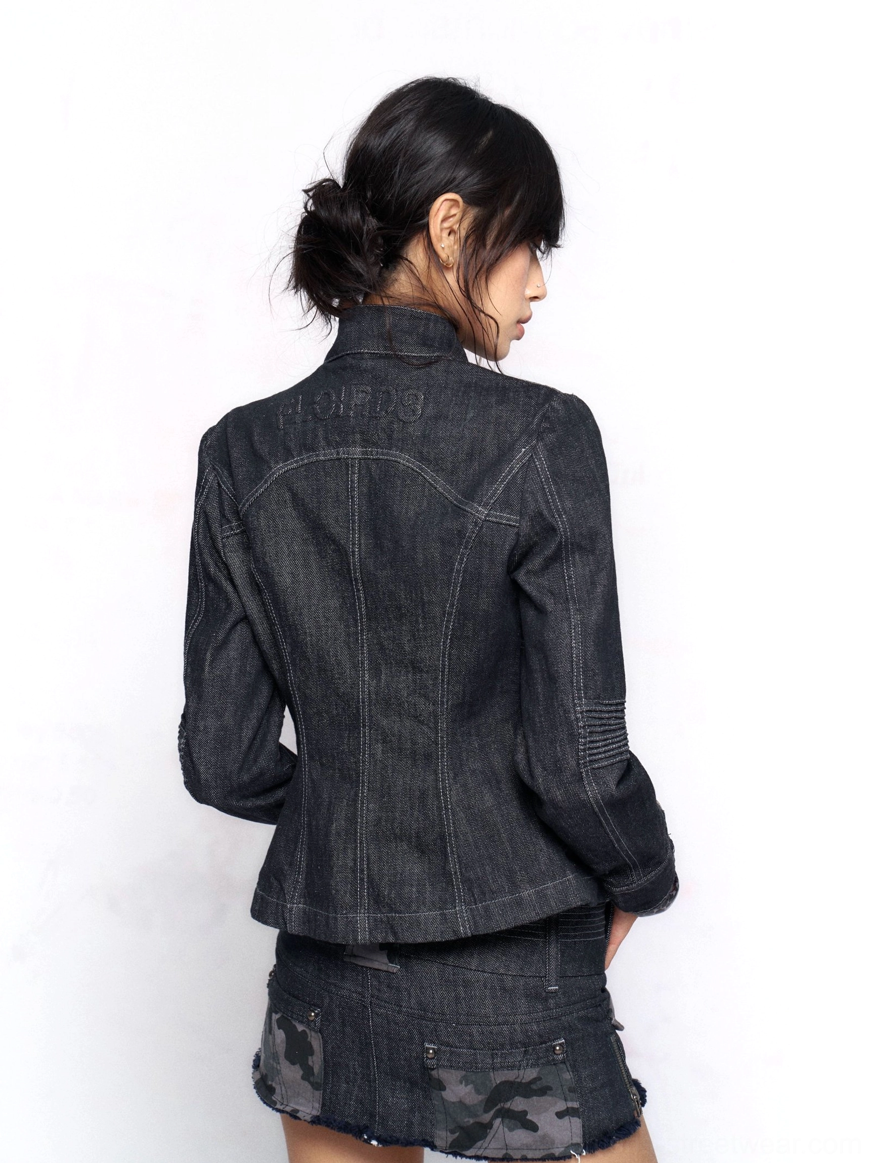 Back view of charcoal camo utility micro skirt with camouflage hem panel styled with a structured stand collar denim jacket