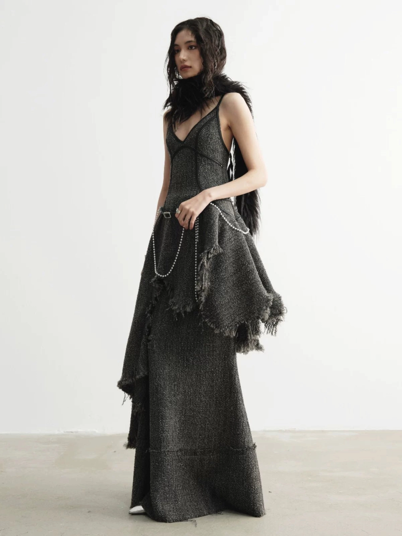 Three-quarter side view of charcoal distressed tweed mermaid skirt with raw frayed asymmetric hip detailing