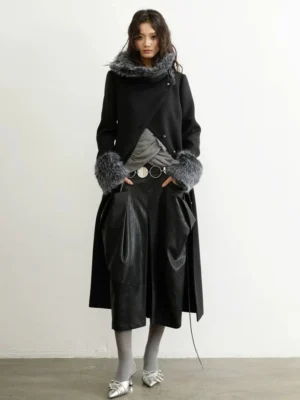 Straight front view of a tailored charcoal fur-trim long coat styled with a gray top, black leather midi skirt, and silver heels