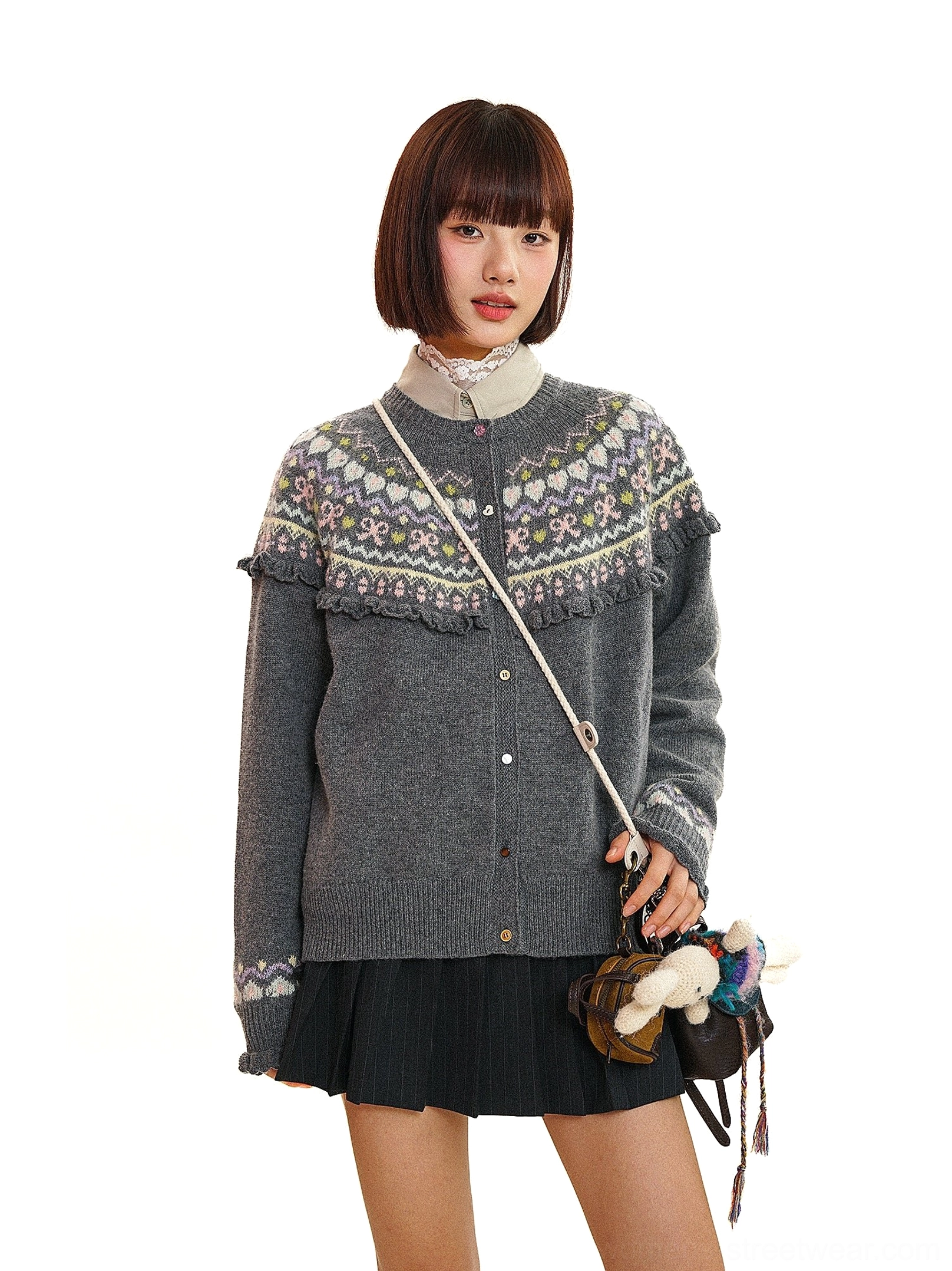Charcoal gray vintage Fair Isle fringe knit cardigan styled with a black pleated mini skirt and retro crossbody bag
