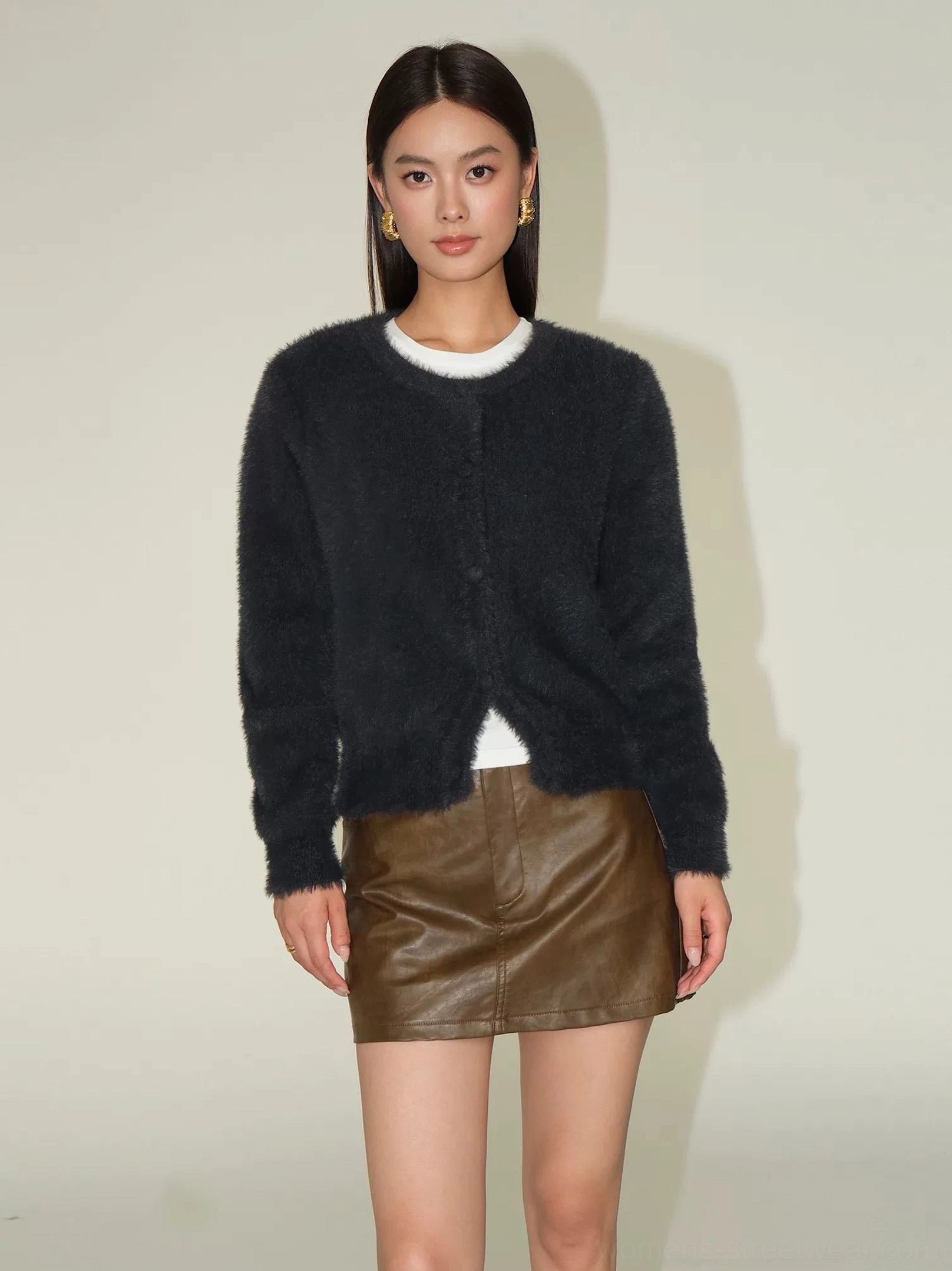 Charcoal gray fuzzy knit cardigan with button front and cropped round neck paired with a brown leather mini skirt and white top