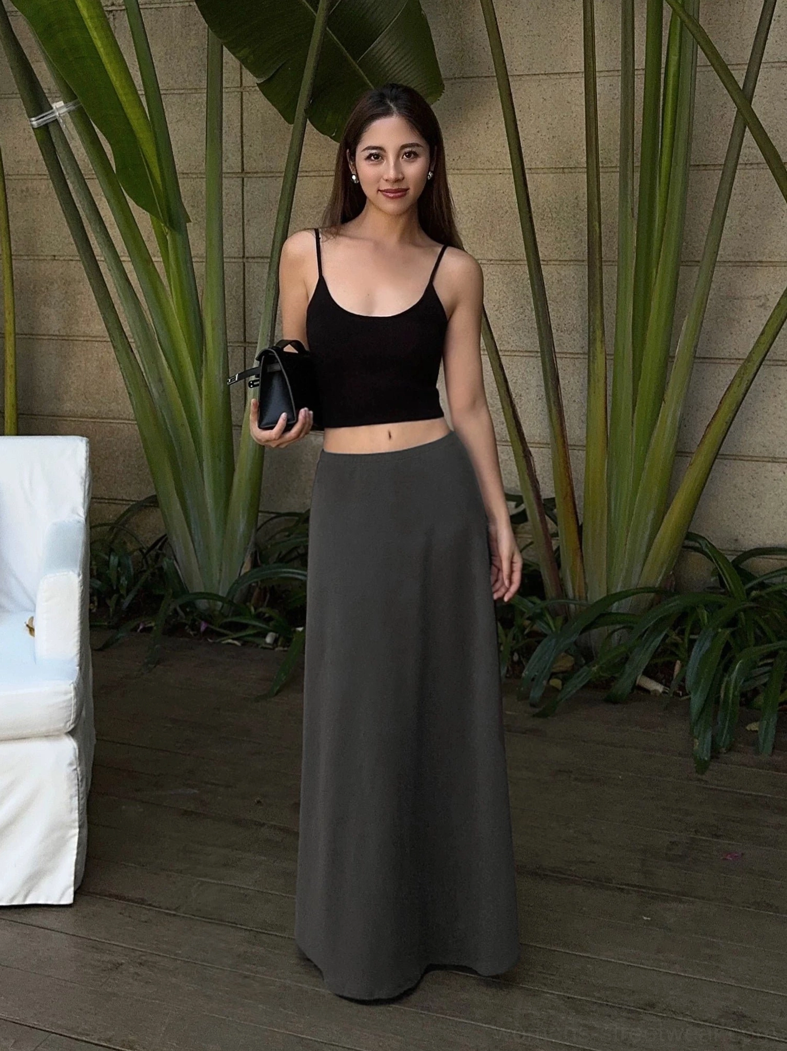 Charcoal gray high-waisted jersey maxi skirt with fluid A-line drape styled with a cropped black camisole