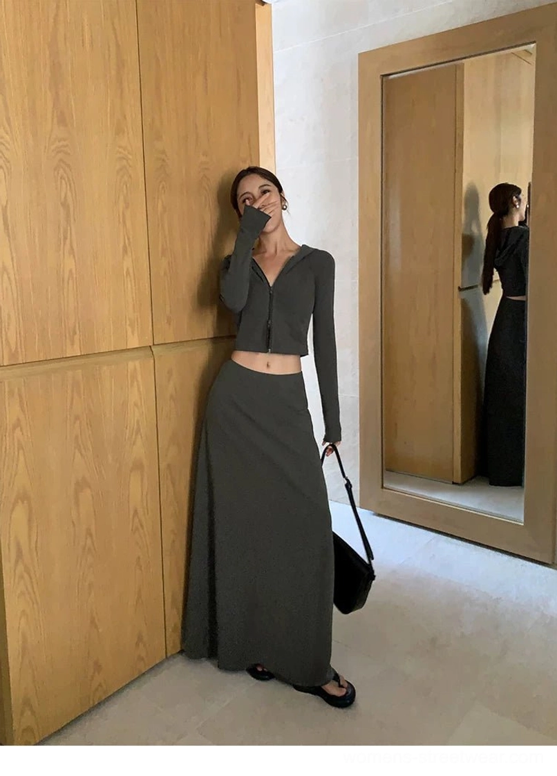 Charcoal gray high-waisted maxi skirt with soft draped knit fabric styled with a cropped long-sleeve top