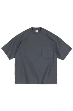 Dark charcoal gray oversized pocket tee with a loose streetwear fit, crew neckline, and dropped short sleeves shown on a studio background