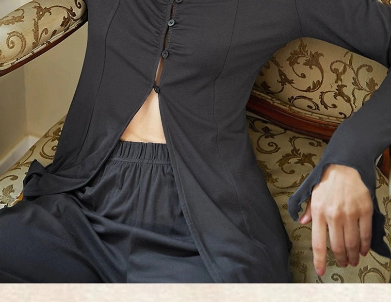 Close-up detail of charcoal gray soft jersey loungewear set showing front buttons, exposed midriff, elastic waistband, and flared cuffs