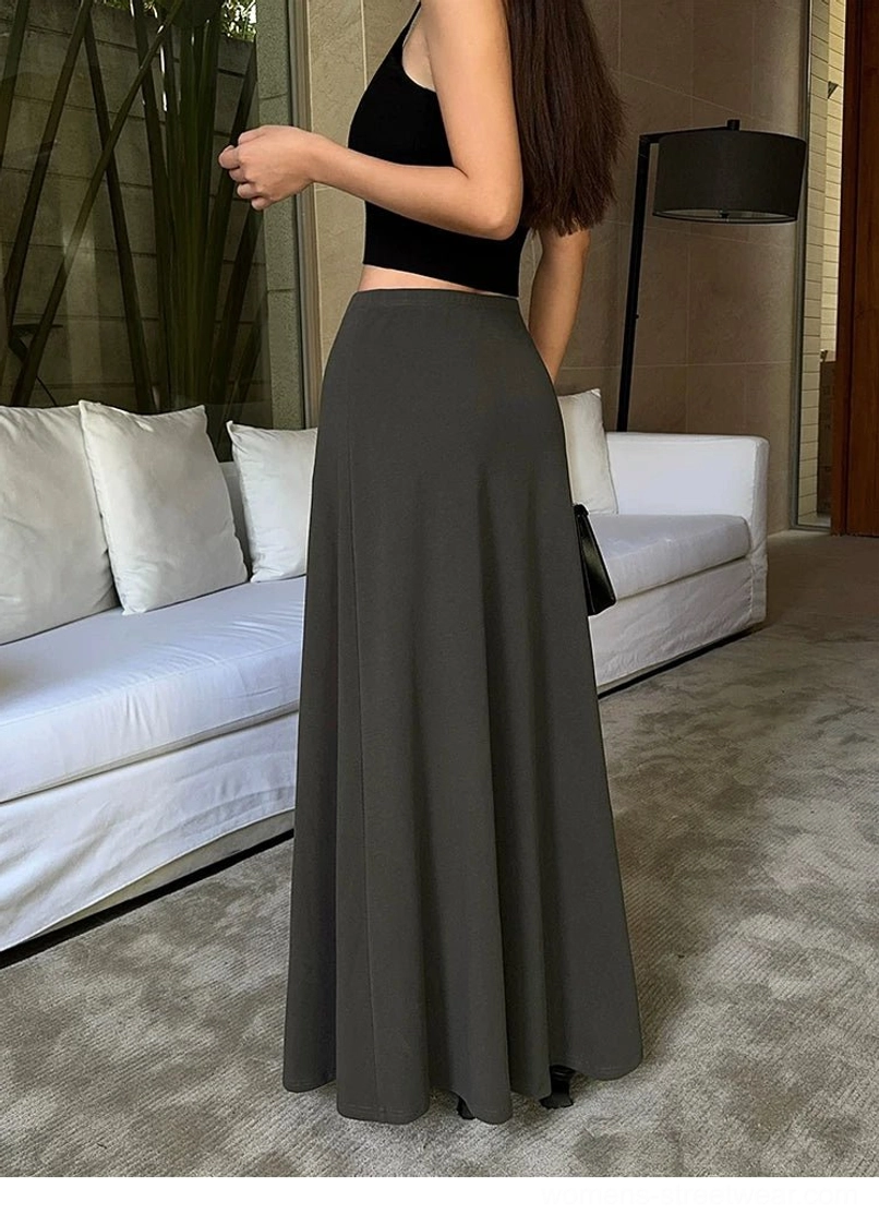 Charcoal gray side-back view of a soft jersey maxi skirt styled with a cropped black camisole