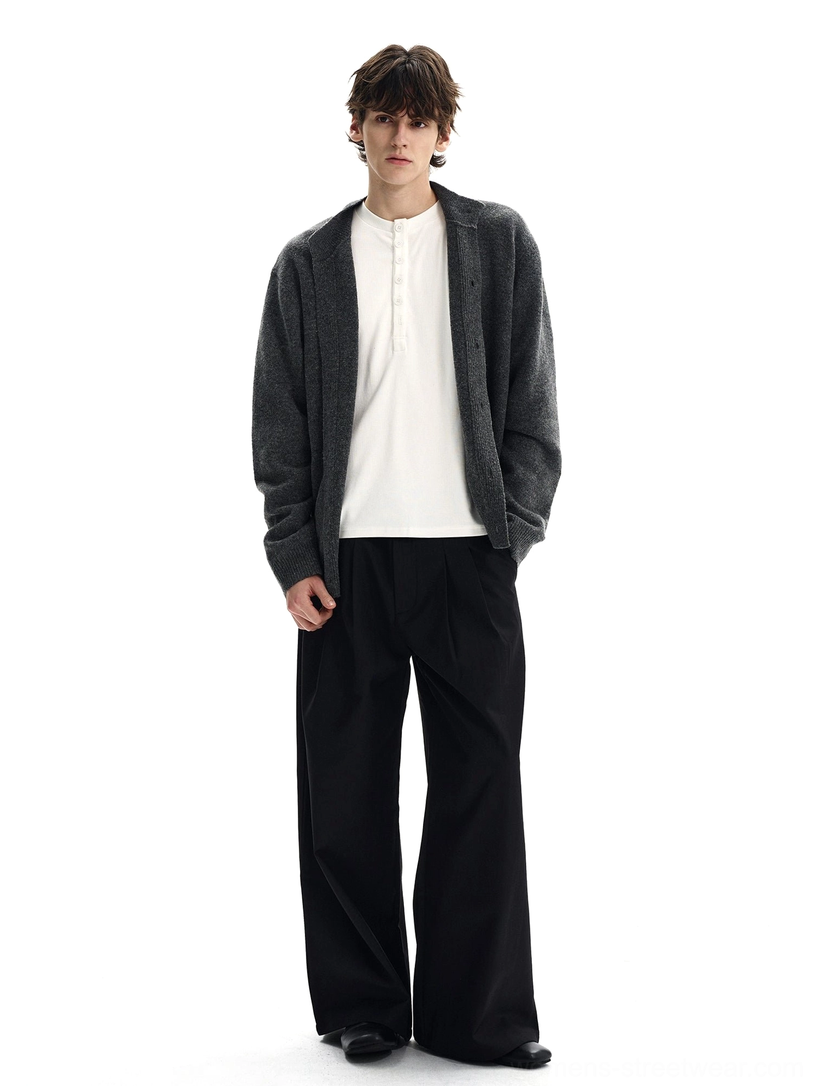 Charcoal button front knit cardigan layered over white henley shirt with black wide leg trousers