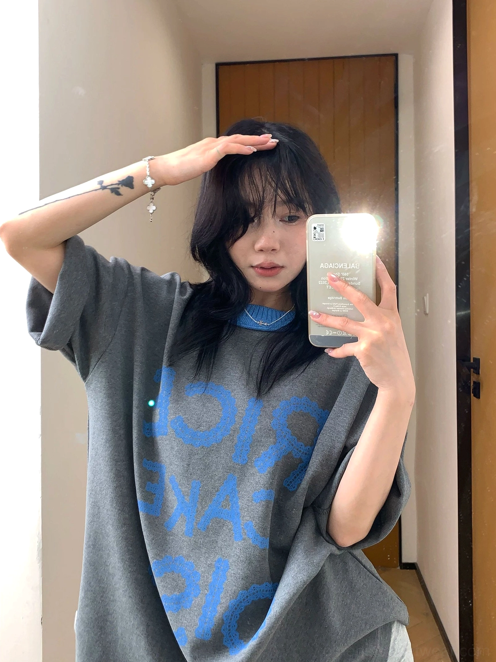 Charcoal oversized graphic streetwear T-shirt with reversed blue RICE CAKE 015 print, contrast ribbed crew neck, and rolled sleeves shown in a front mirror selfie