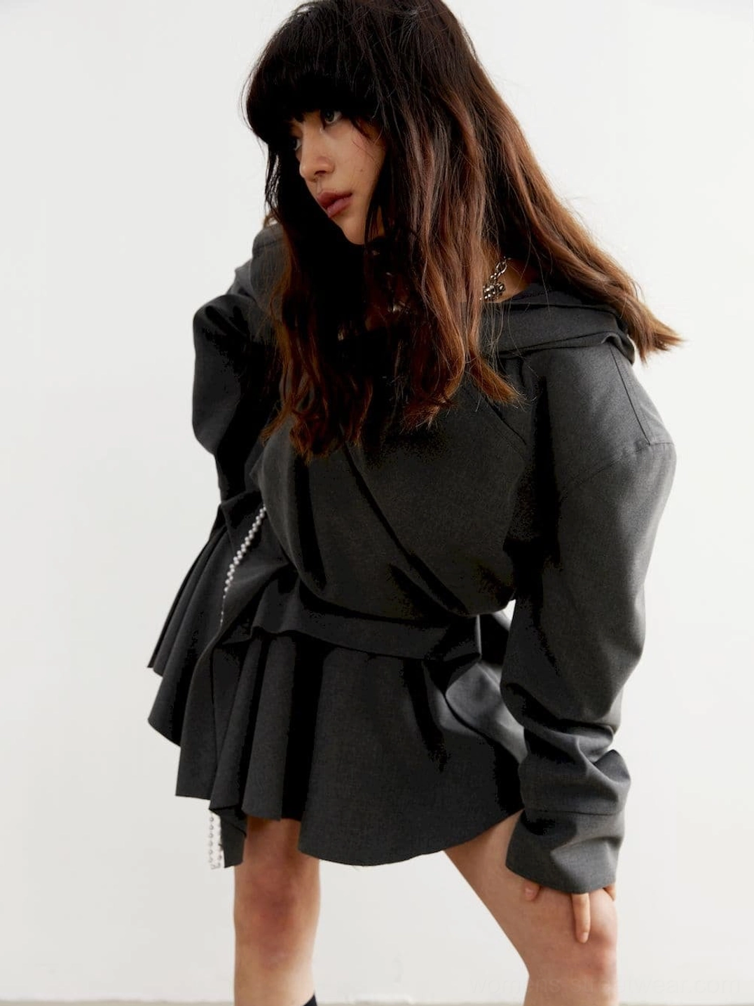 Low angle view of charcoal oversized cropped hoodie with draped asymmetrical front design and solid dark gray fabric