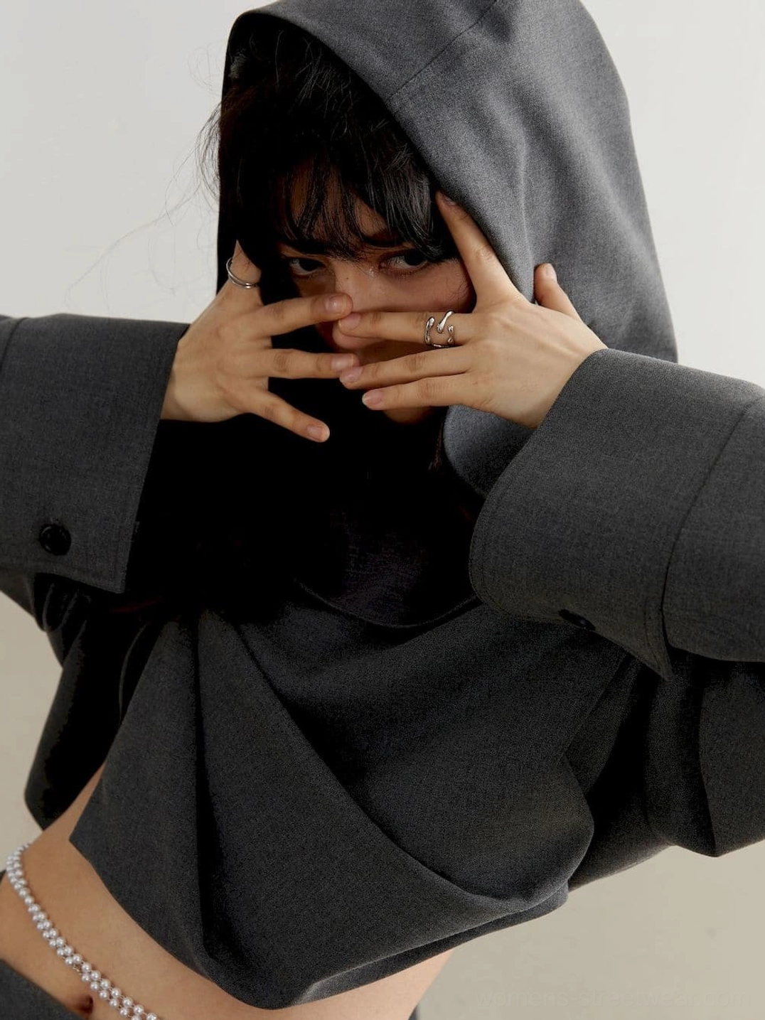 Close-up view of charcoal oversized cropped hoodie with roomy hood, dropped shoulder, long sleeves, cuff buttons, and pearl waist chain
