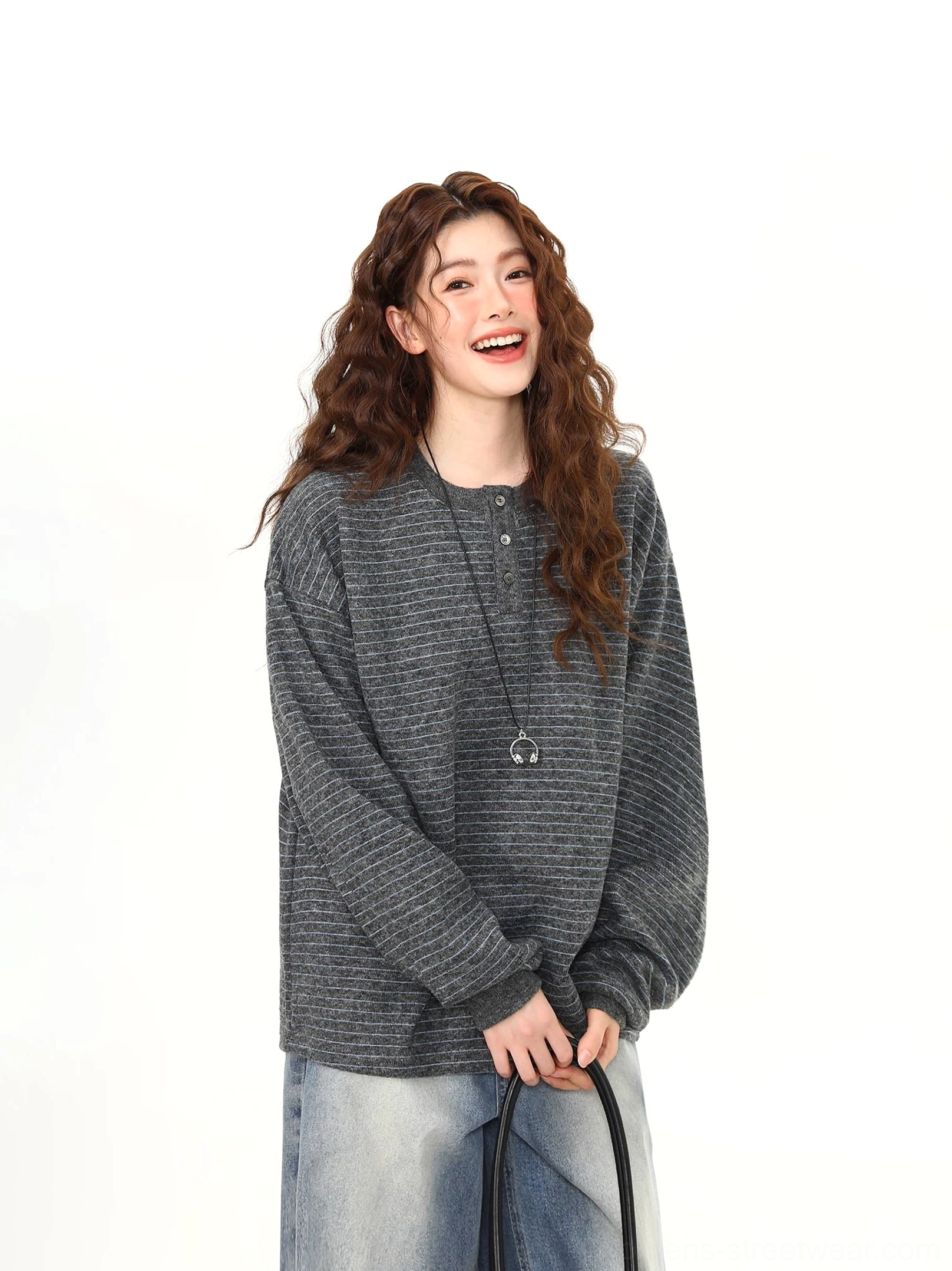 Close up of fine gray horizontal stripe knit texture and button Henley neckline on oversized charcoal streetwear pullover