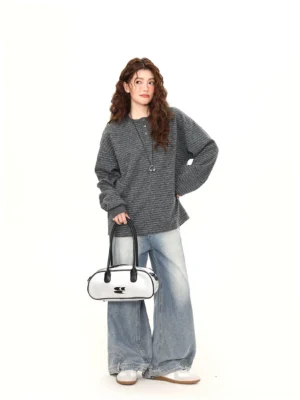 Full body styling view of gray oversized striped Henley knit pullover paired with light wash wide leg jeans and white sneakers