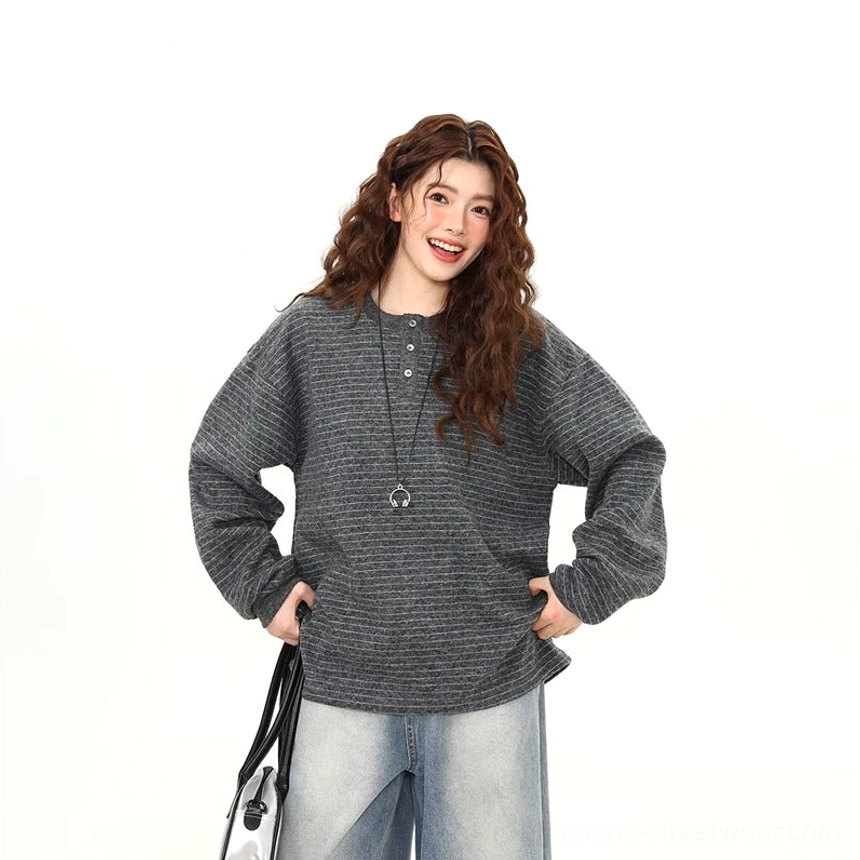 Front upper view of gray striped oversized Henley knit pullover with button placket soft textured knit and pendant necklace styling