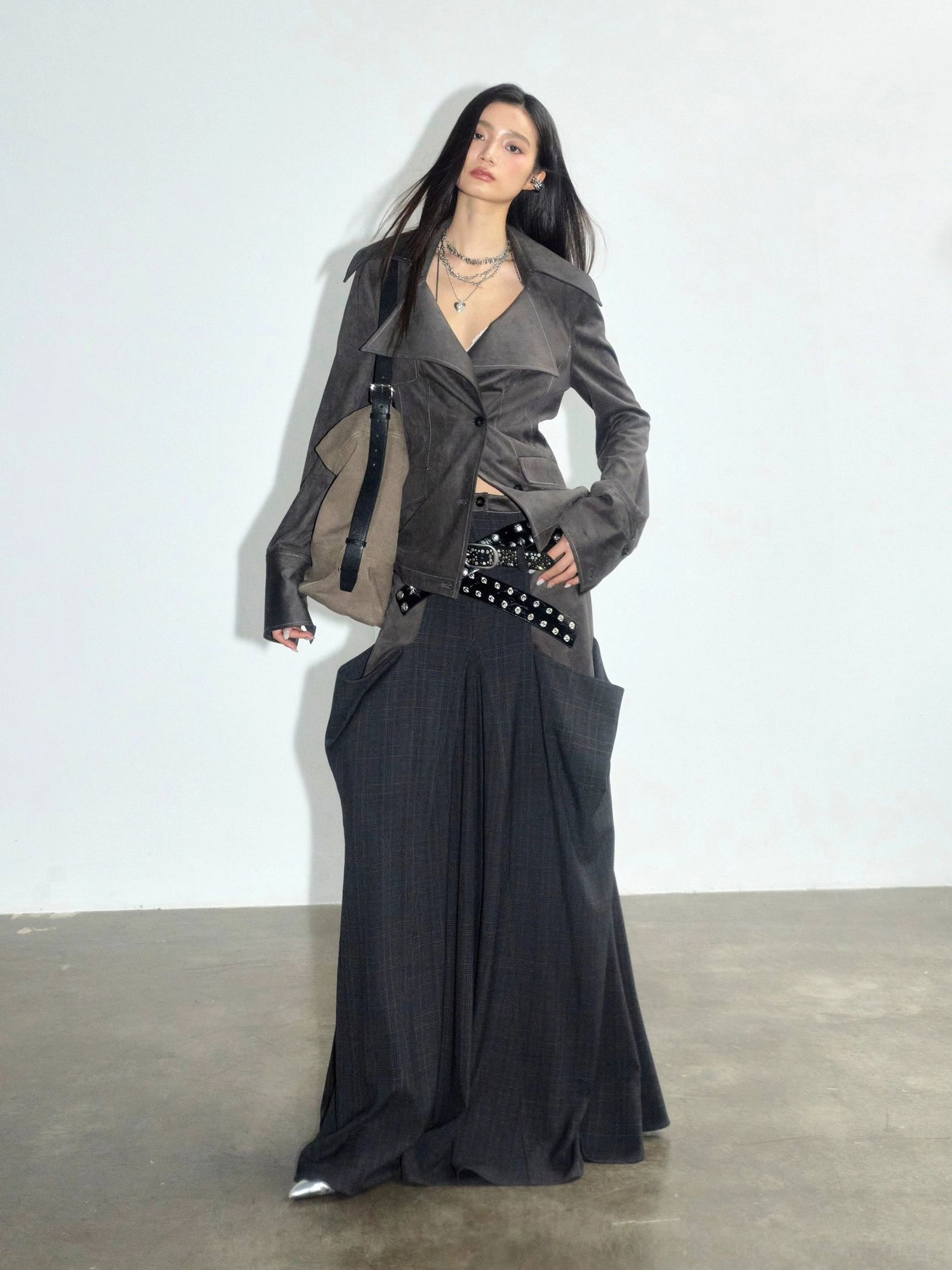 Charcoal suede and plaid panel maxi skirt styled with matching blazer, studded belt and crossbody bag in a front three-quarter studio look