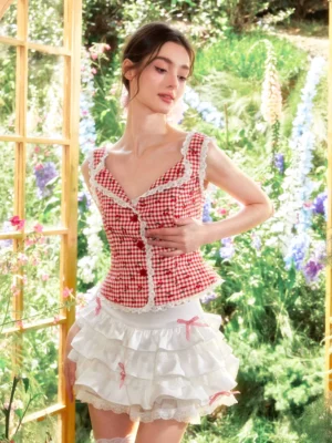 Cherry gingham lace top and white tiered ruffle mini skirt styled as a coquette streetwear outfit in a sunny flower garden