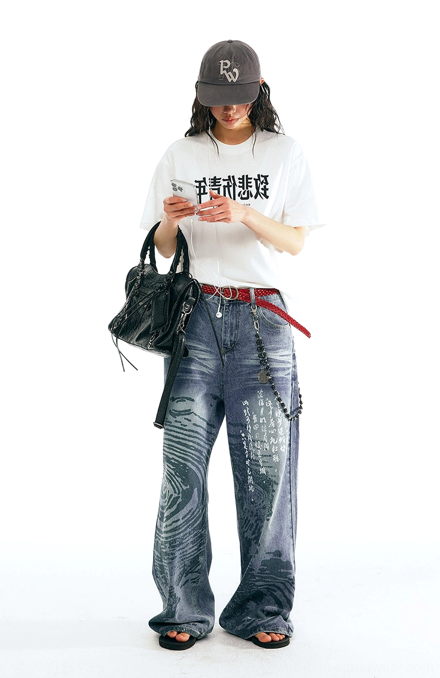 Female streetwear outfit featuring Chinese calligraphy wave print wide straight-leg jeans with red belt and black handbag