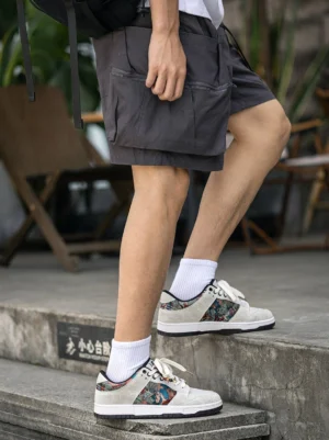 Chinese embroidered bird brocade court sneakers styled with grey cargo shorts white crew socks and urban concrete stairs