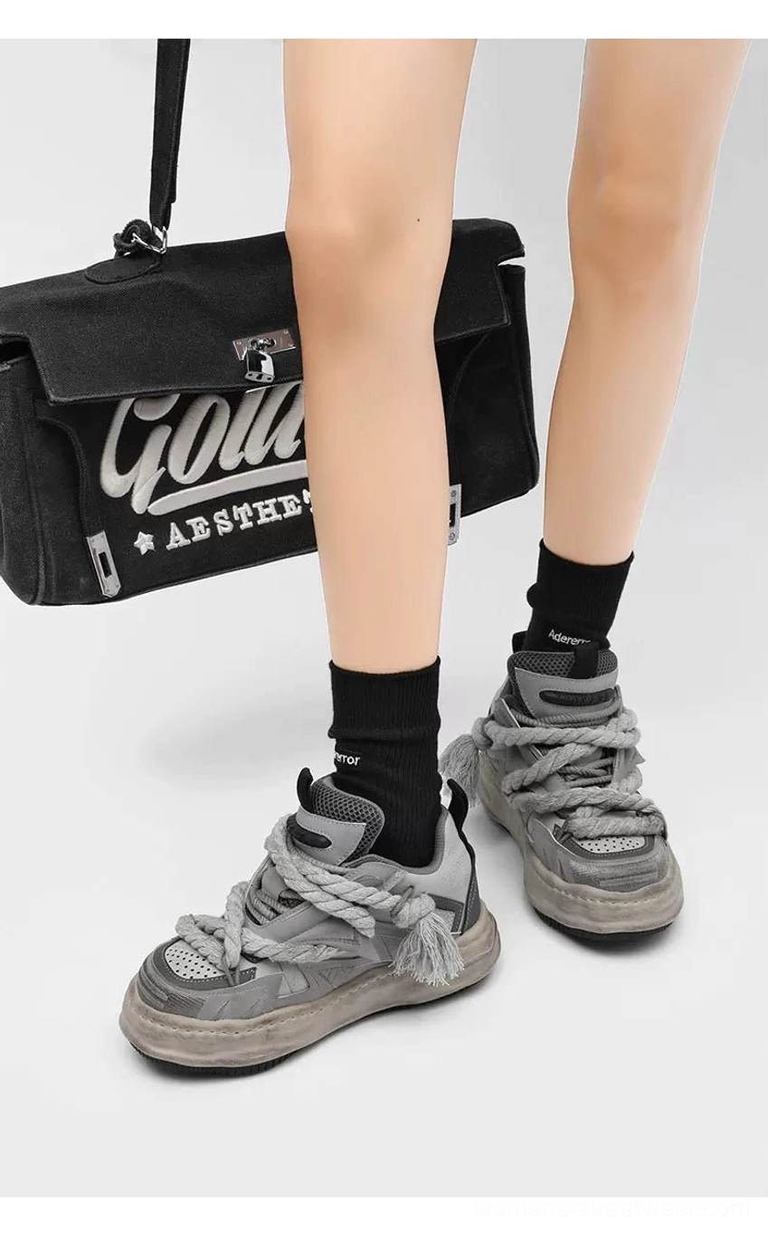 Chunky low-top streetwear sneakers with exaggerated rope laces, geometric layered panels, distressed platform outsole, and expressive deconstructed footwear styling