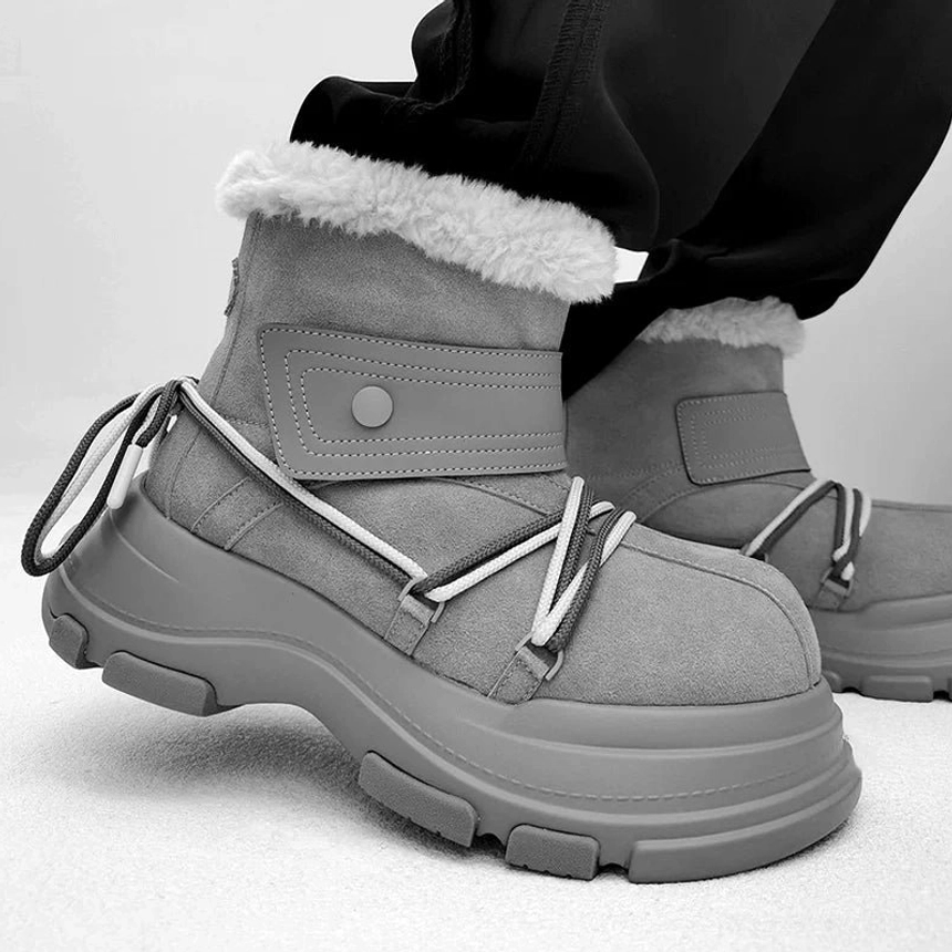 Gray chunky platform shearling snow boot worn with black pants showing contrast laces, fleece collar, and thick sole