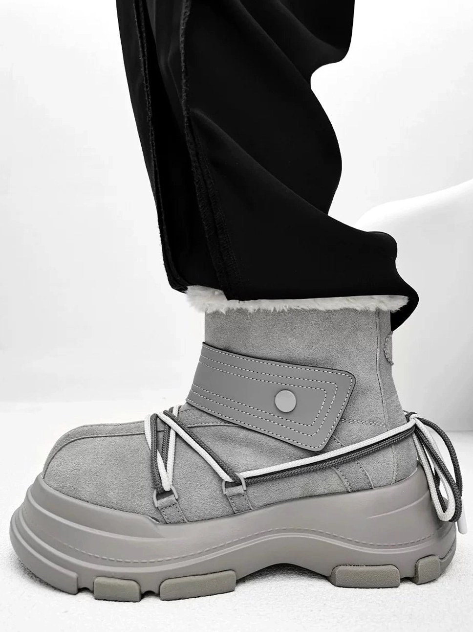 Gray suede-finish platform snow boot side profile with plush faux shearling cuff and utility strap detail
